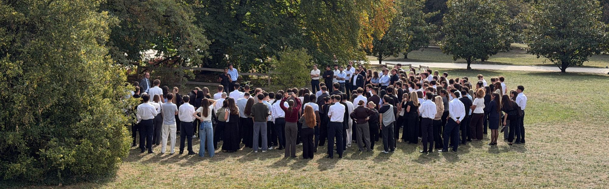 Grand groupe d'entreprise lors du briefing d'un team building en plein air