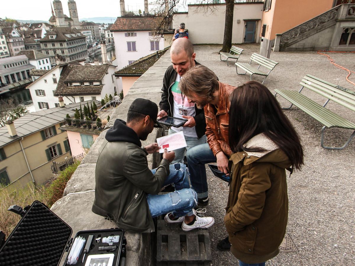 Team entschlüsselt einen Hinweis mit Tablet und Agentenkoffer beim Outdoor Escape Game