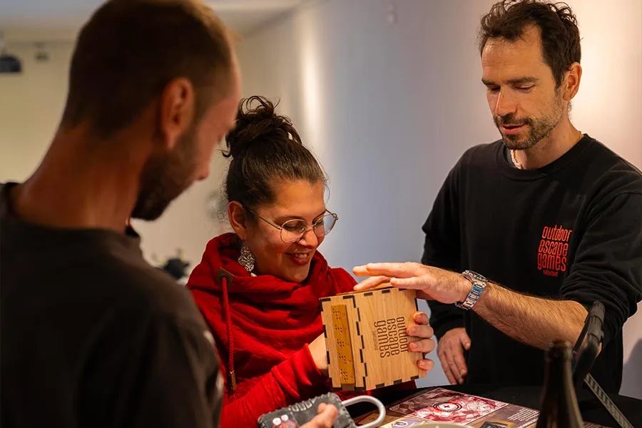 Game Master erklärt einer Teilnehmerin die Rätselbox